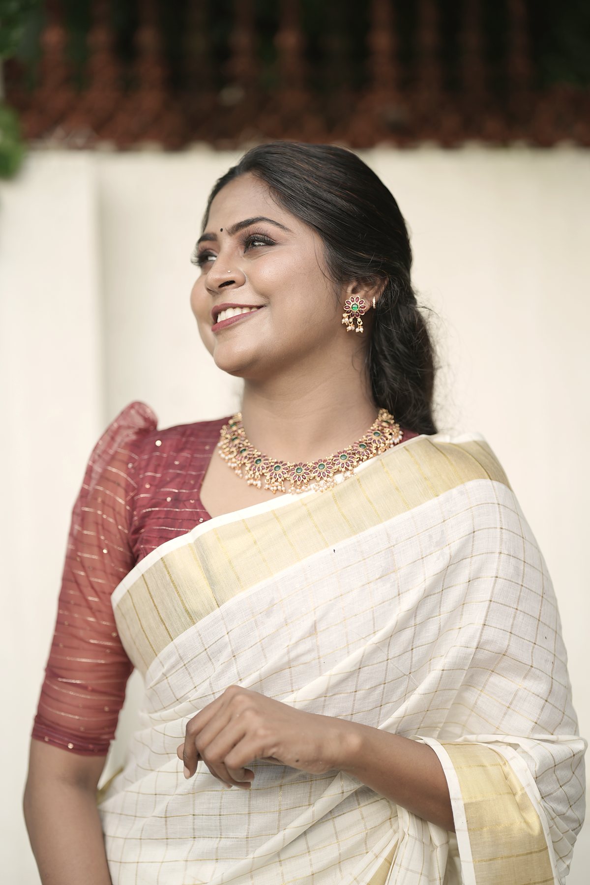 Dr. Aiswaryia Mohan in a kasavu saree, looking up and smiling